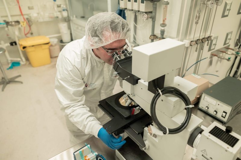 A researcher uses equipment in a semiconductor cleanroom.